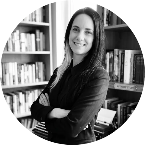 Porträt von Elisabeth Marenfeld, Schwarzweißaufnahme vor einem Bücherregal.